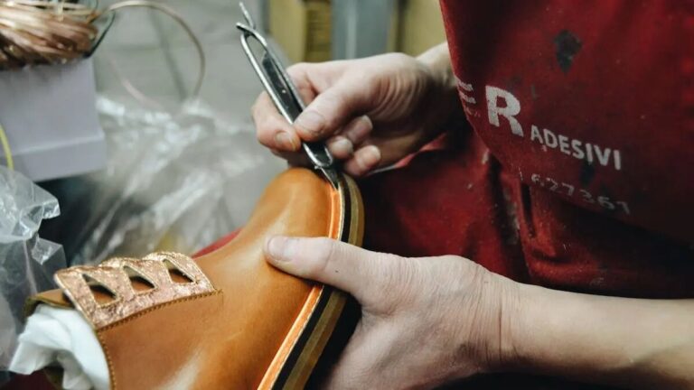 A man diligently repairs a pair of shoes, showcasing craftsmanship and attention to detail in his work