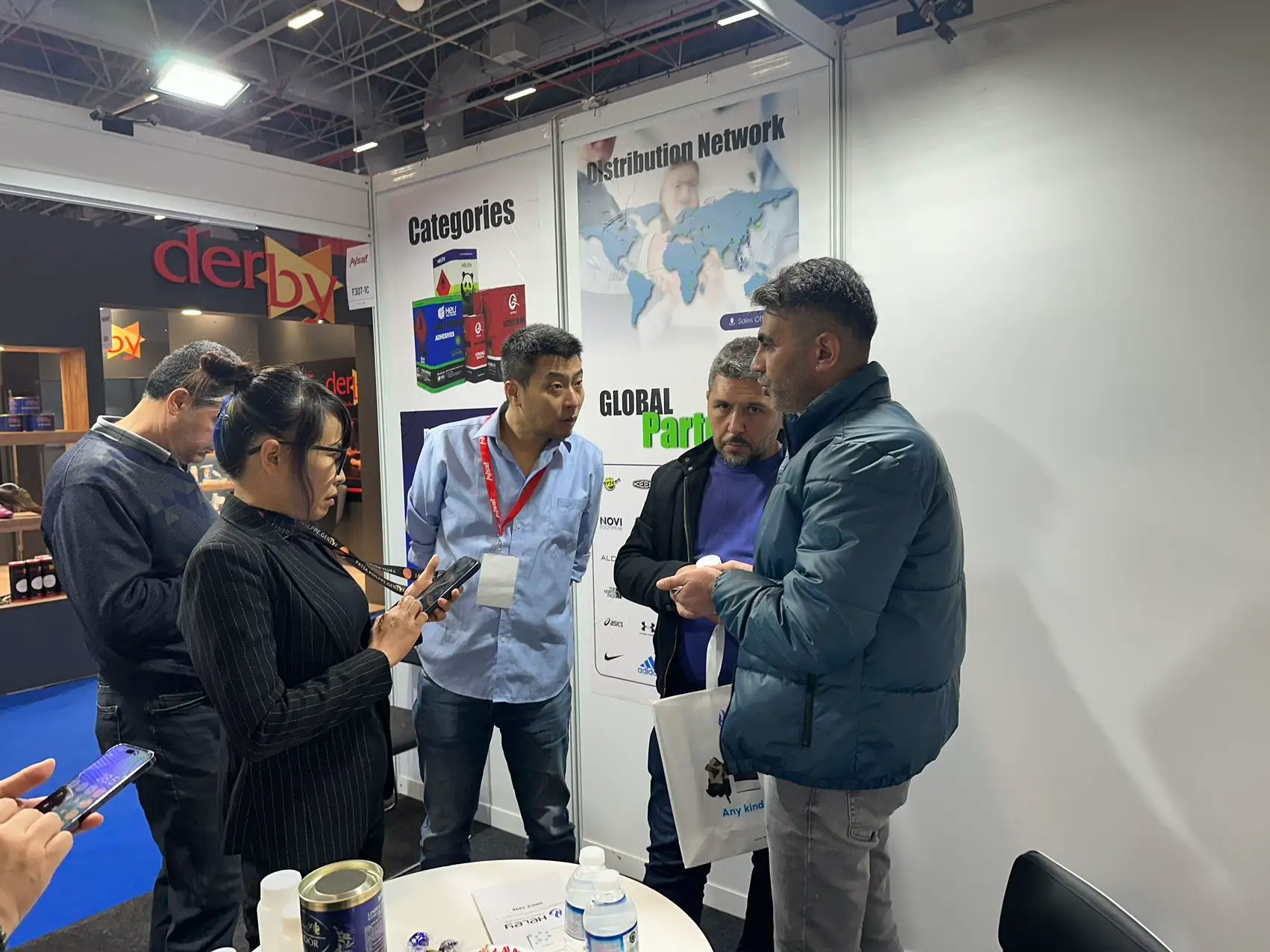 visitors discuss adhesive solution with Heley at AYSAF Expo 2024