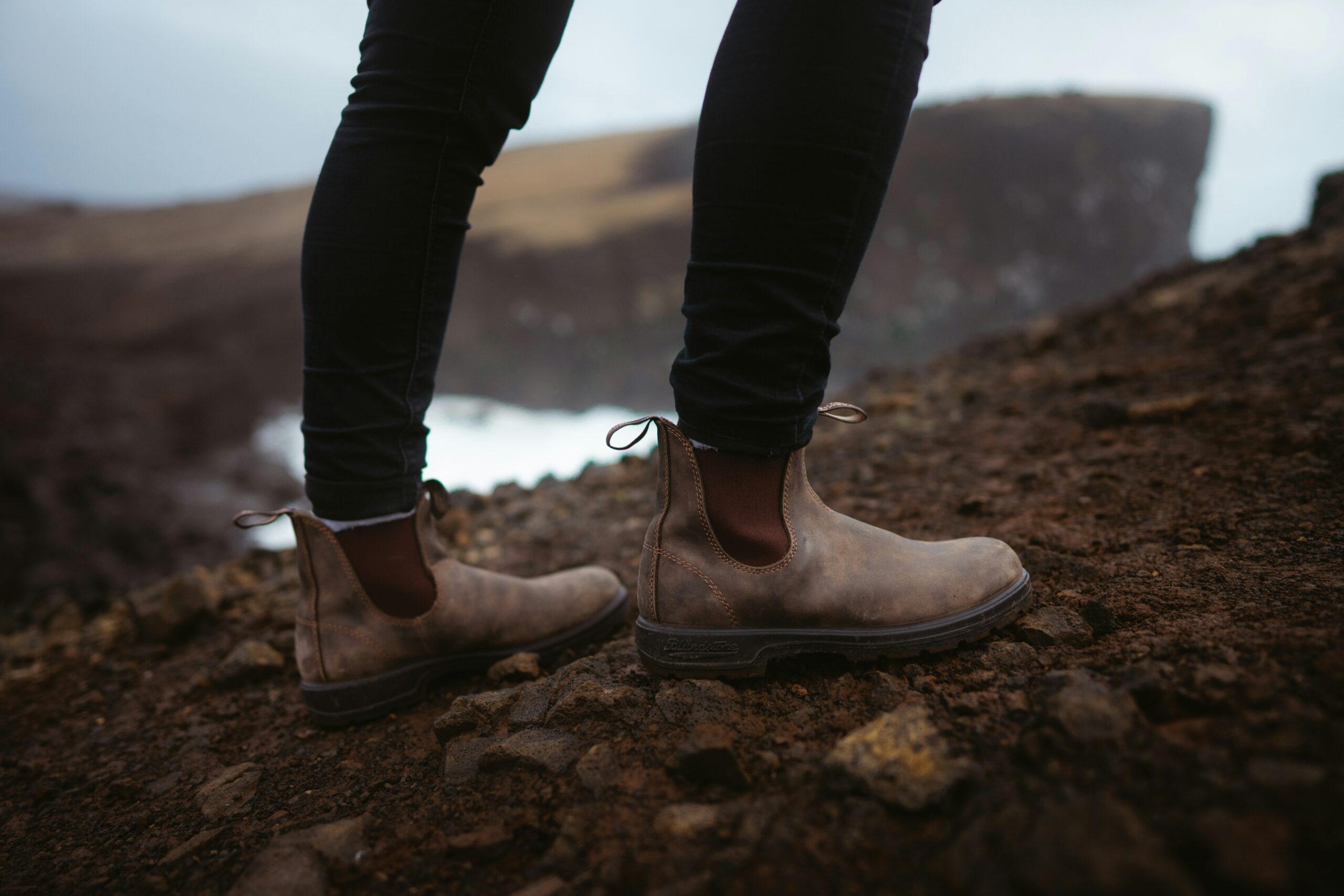 image captures rugged brown boots on rocky terrain showcasing their durability and temperature resistance for outdoor activitie