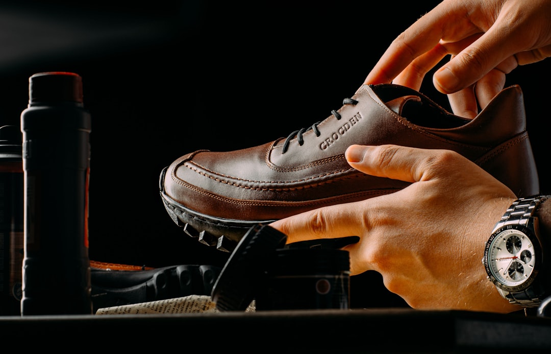 person holding a pair of brown shoes