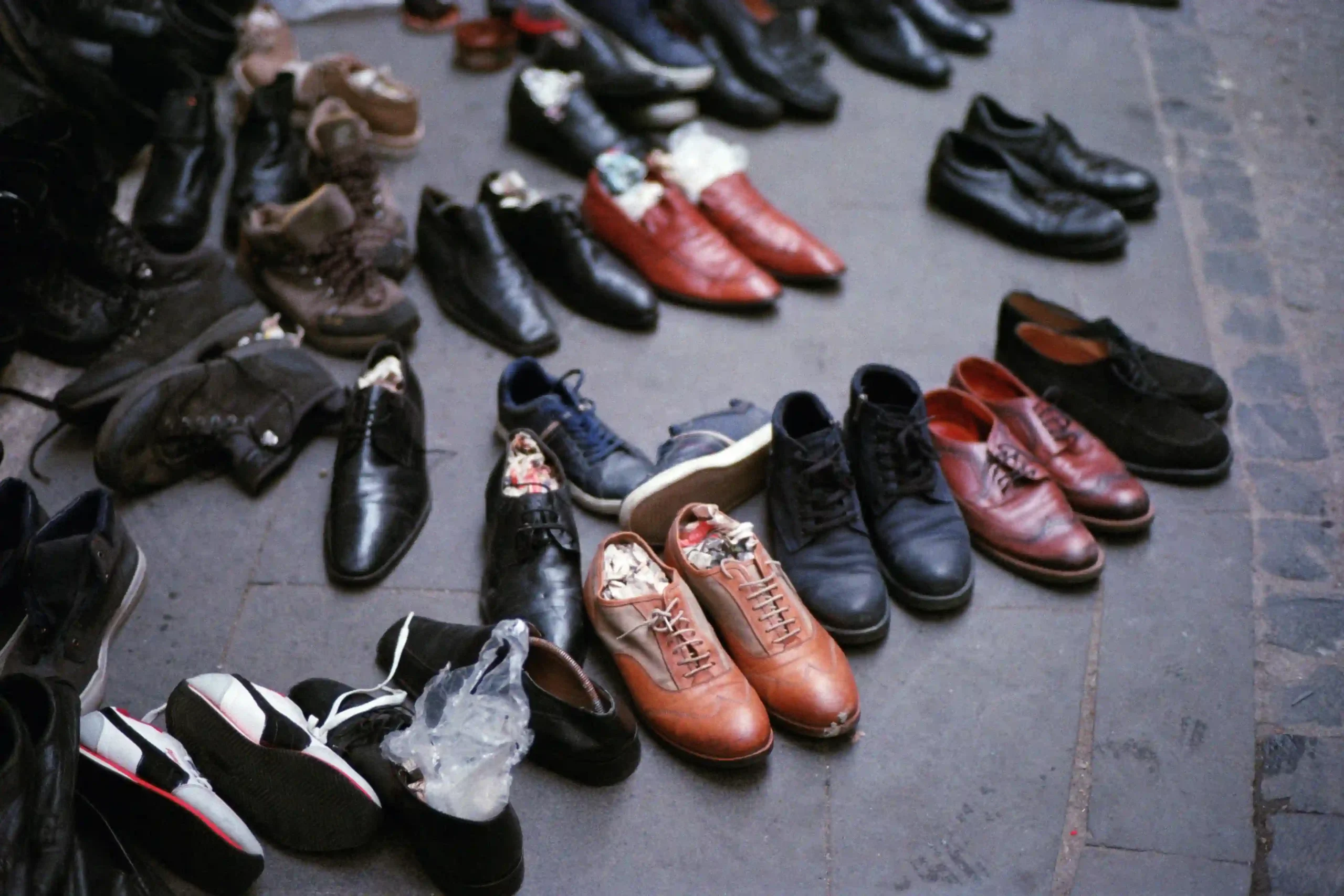 image depicts a variety of shoes scattered on the ground, some of which may be assembled using chloroprene adhesives for durability and flexibili.