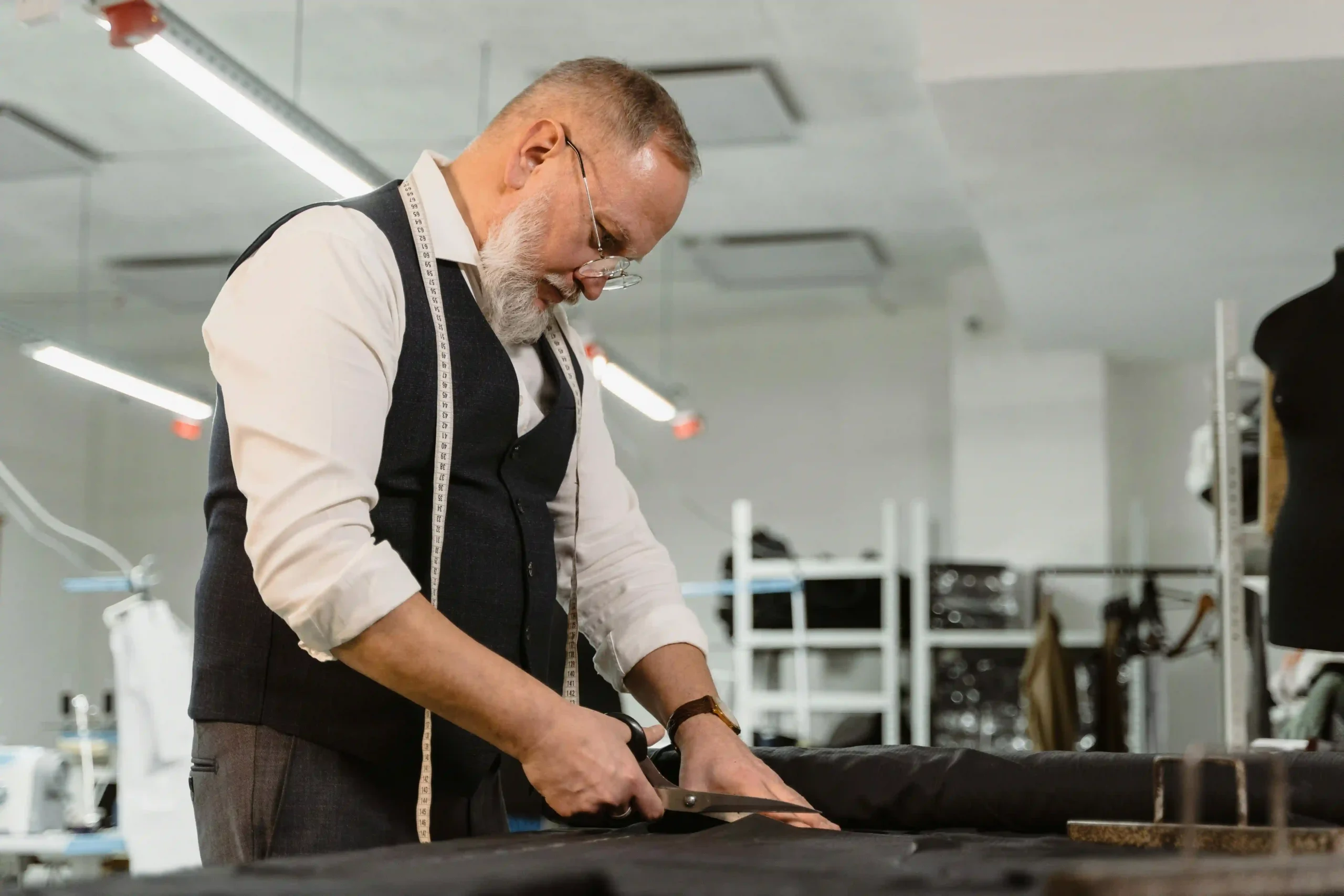 a tailor is measuring and cutting the fabric.