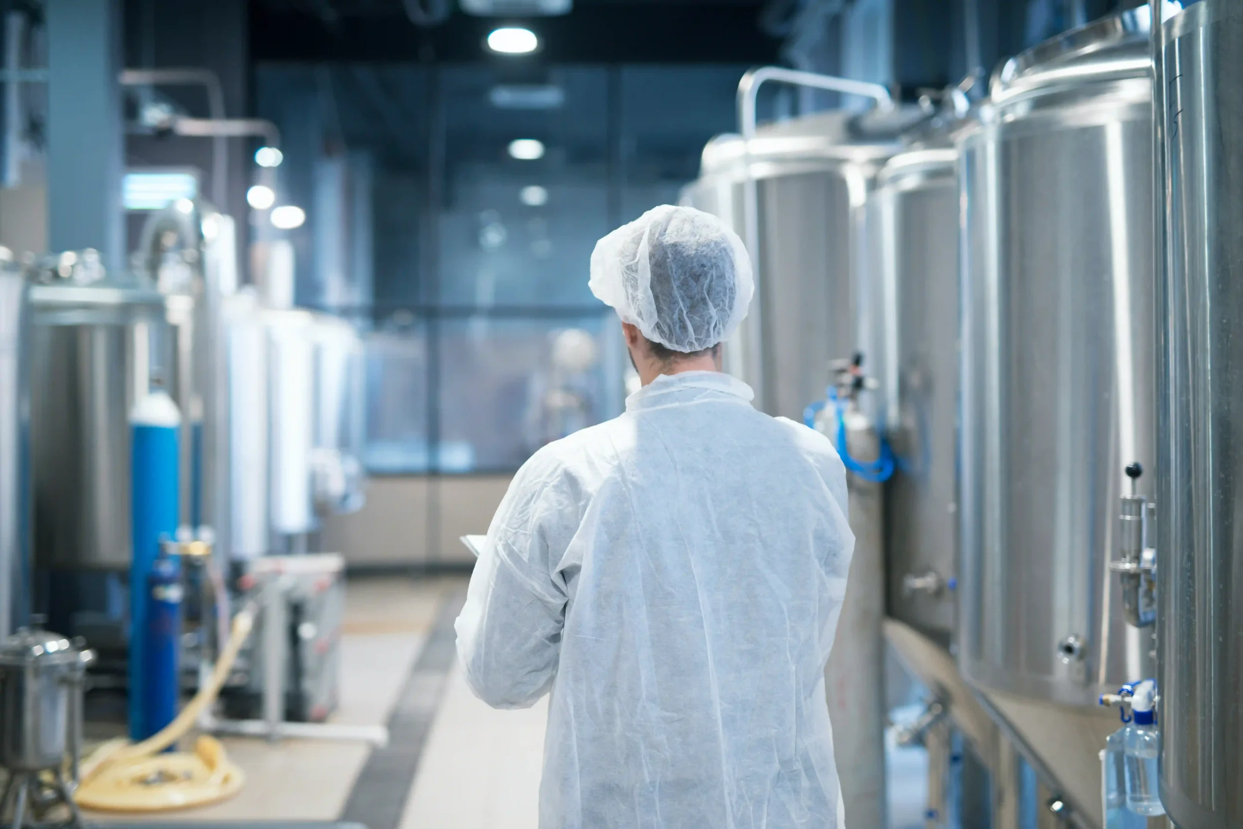 technologist-white-protective-suit-walking-through-food-factory-production-line-checking-quality