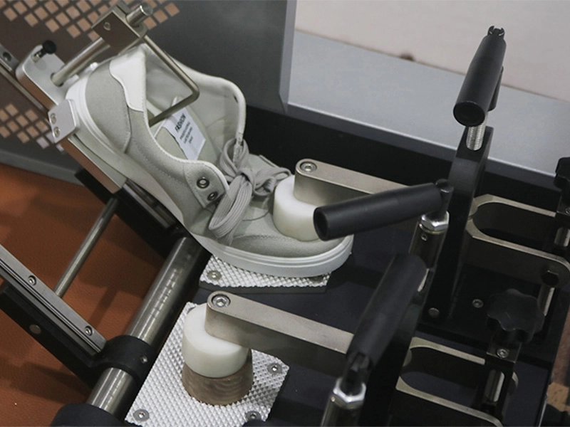 The picture illustrates the principle of the flexibility test for shoes.