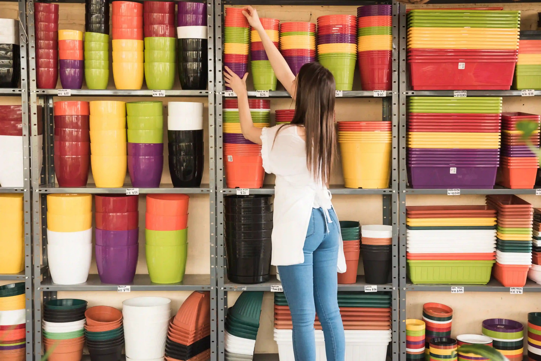 woman-placing-stacked-flowering-pots-shelf