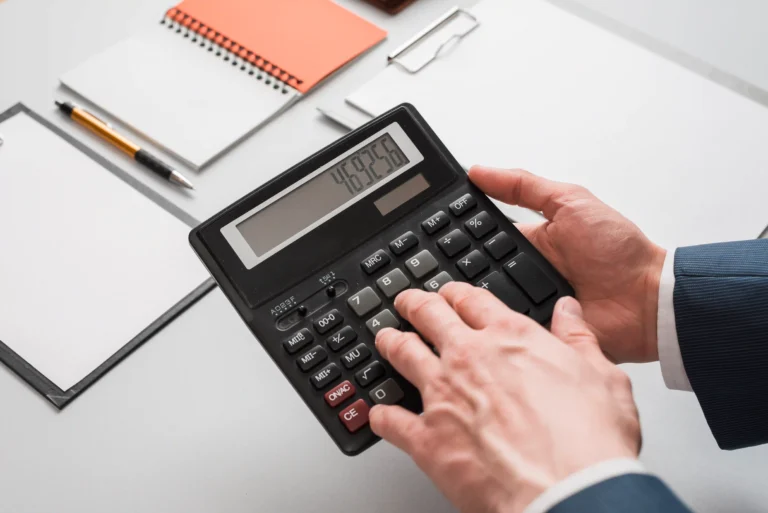hands are using a calculator to cost accounting for footwear product.